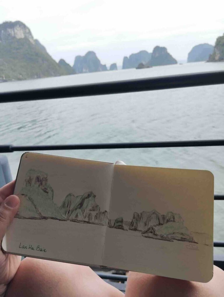 carnet de voyage de croquis ouvert face a un paysage idyllique