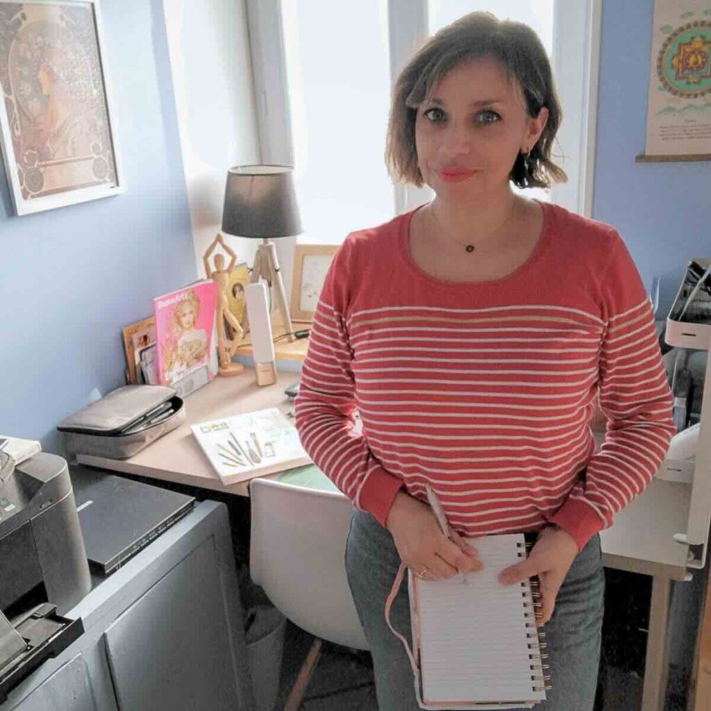 selfie femme illustratrice qui tient un carnet à. la main