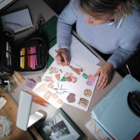 vue dessus illustratrice réalisant des dessins d aliments aux crayons de couleur